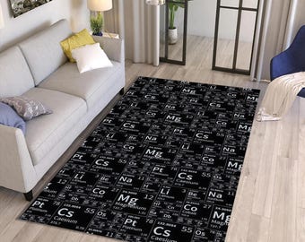 Könnte beinhalten: Schwarzer rechteckiger Teppich mit einem Periodensystem-Design. Der Teppich zeigt Elementsymbole, Ordnungszahlen und Atomgewichte in Weiß auf schwarzem Hintergrund. Der Teppich befindet sich in einem Wohnzimmer.