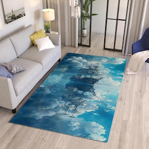 Könnte beinhalten: Ein rechteckiger Teppich mit einer detaillierten Illustration eines hohen Schiffes, das durch einen bewölkten Himmel segelt. Das Design des Teppichs enthält Farbtöne von Blau, Weiß und Grau und erzeugt eine verträumte, künstlerische Ästhetik. Der Teppich liegt auf einem Holzboden.