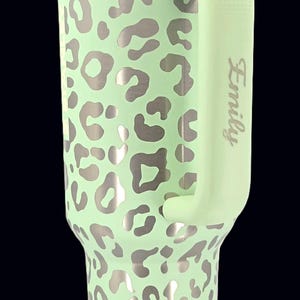 Puede incluir: Un letrero de madera hecho a mano con el texto "Welcome to our home" en un estilo manuscrito. El letrero est&aacute; pintado de blanco con un marco te&ntilde;ido oscuro. Una peque&ntilde;a planta verde est&aacute; colocada encima.