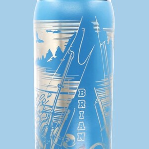 May include: Blue insulated water bottle with a silver fishing scene design. The bottle features the name "BRIAN" vertically and the brand name "Cowala". The lid is gray and white.
