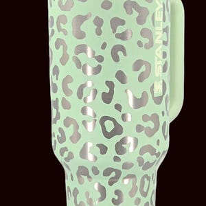 Puede incluir: Una taza de cer&aacute;mica blanca con un asa negra y el texto "But First, Coffee" en un estilo manuscrito. La taza est&aacute; sobre una superficie blanca. La taza mide 10 cm de alto.