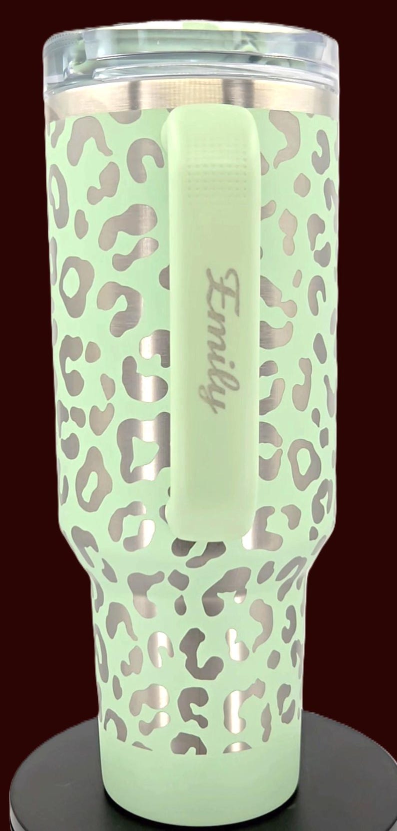 Puede incluir: Un vaso de color verde menta con un dise&ntilde;o de estampado de leopardo plateado. El vaso tiene un asa verde menta a juego con el nombre "Emily" impreso verticalmente. El vaso est&aacute; dise&ntilde;ado para contener bebidas.