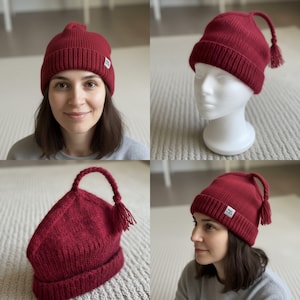 May include: Four images displaying a deep red knitted beanie hat. The hat has a ribbed texture, a small tag, and a distinctive curved top with a tassel. One image shows the hat on a person, another on a mannequin head, and two other angles.