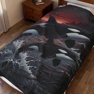 May include: A bed blanket featuring a graphic print of two orcas swimming through dark, crashing ocean waves. The design includes a deep red and dark sky background with rocky silhouettes, creating a dramatic contrast against the black and white whales.