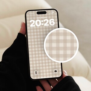 Pode incluir: Um smartphone exibindo um papel de parede digital com padr&atilde;o xadrez vichy em bege e branco. A tela mostra a hora 20:26, a data sen. 30. nov. e &iacute;cones de lanterna e c&acirc;mera. Uma inser&ccedil;&atilde;o circular destaca o detalhe do padr&atilde;o no papel de parede.