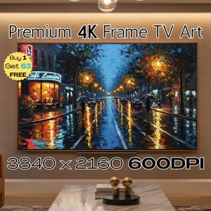 May include: A framed 4K TV art piece displays a vibrant street scene. The artwork depicts a rainy night with reflections of streetlights and a cafe. The text "Premium 4K Frame TV Art" and "Café Lumière" are visible.