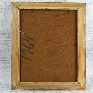May include: The back of a framed painting with a brown canvas and a wooden frame. The canvas has the number "1964" written on it in black ink.