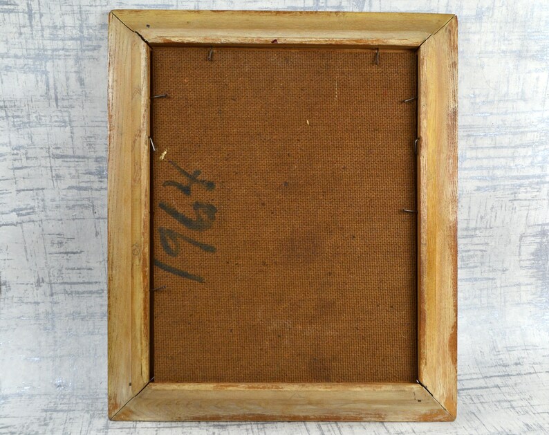 May include: The back of a framed painting with a brown canvas and a wooden frame. The canvas has the number "1964" written on it in black ink.