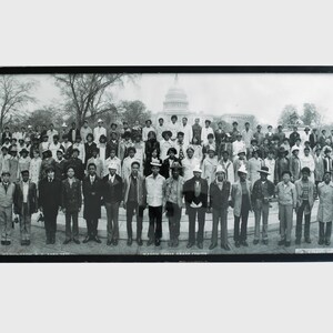 Puede incluir: Fotografía en blanco y negro de un gran grupo de personas de pie frente al edificio del Capitolio de los Estados Unidos. El grupo está formado principalmente por adultos y niños, todos vestidos con ropa de la década de 1970.