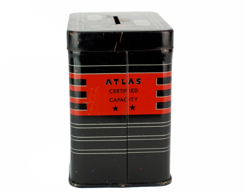 K&ouml;nnte beinhalten: Schwarze Metall-Sparb&uuml;chse mit einem roten Streifen und wei&szlig;er Aufschrift "ATLAS CERTIFIED CAPACITY" mit zwei Sternen.