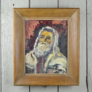 May include: A framed oil painting of a man with a white beard and a white robe. The background is a dark red and the painting is in a wooden frame.
