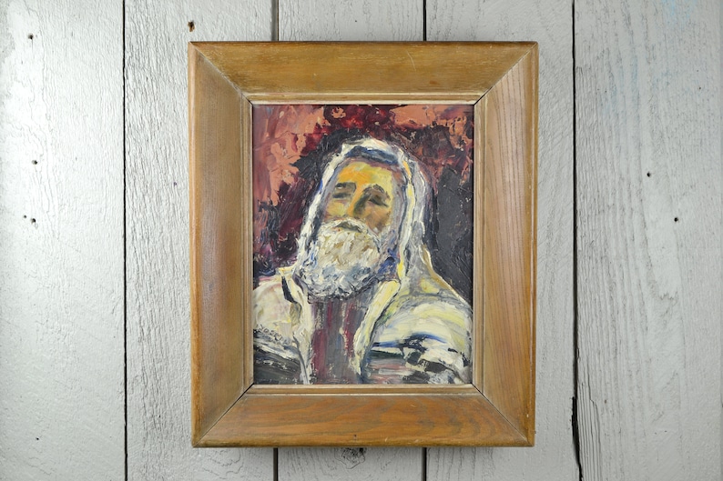 May include: A framed oil painting of a man with a white beard and a white robe. The background is a dark red and the painting is in a wooden frame.