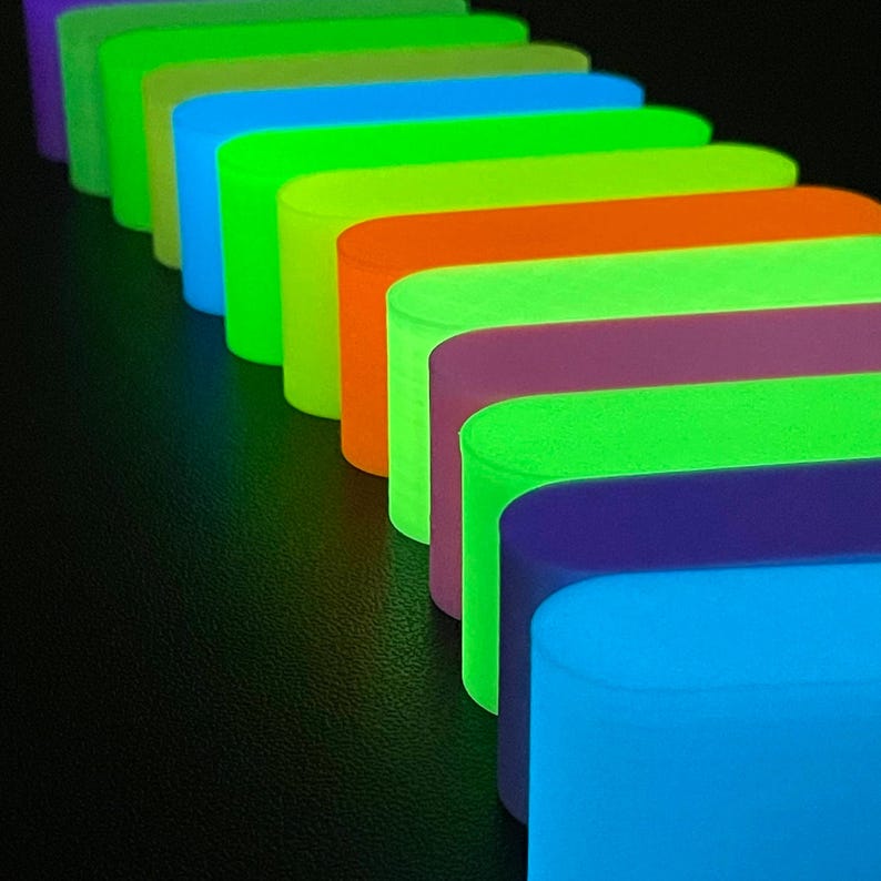 May include: A series of rectangular blocks arranged in a diagonal line, each featuring a vibrant neon color including blue, purple, green, yellow, and orange. The blocks have rounded edges and a smooth, matte finish, creating a colorful sequence.