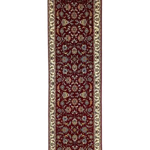 May include: A rectangular, ornate runner rug with a deep red field and a cream-colored border. The rug features a detailed floral pattern in shades of blue, gold, and cream. The design is symmetrical, creating a classic and elegant look.