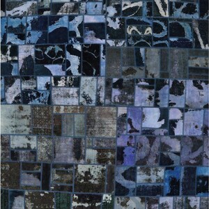 May include: A patchwork rug with a distressed, vintage aesthetic. The rug features a mosaic of rectangular and square patches in shades of blue, black, and gray. The design has a faded, worn appearance, suggesting age and use.