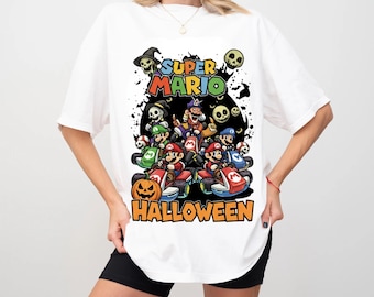Może przedstawiać: Biała koszulka z kolorową grafiką postaci Super Mario w gokartach z motywem Halloween. Projekt zawiera czaszki, dynię i napisy "Super Mario Halloween".