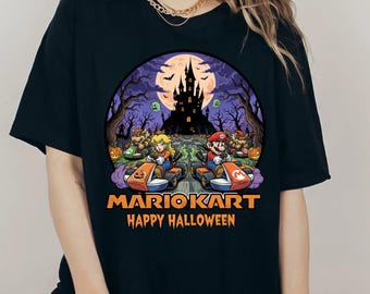 Może przedstawiać: Czarny t-shirt z motywem Mario Kart w stylu Halloween. Projekt przedstawia Mario i Peach ścigających się w gokartach, straszny zamek i napis "MARIO KART HAPPY HALLOWEEN" w kolorze pomarańczowym.