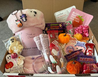 May include: A Halloween-themed gift box containing a pink ghost throw blanket, a glass mug with ghost graphics, a ghost-shaped treat, a Sadoer face mask, a strawberry skin care mask, Haribo candy, a KitKat bar, two small pumpkins, and keychains.