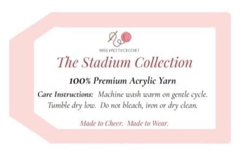 May include: A light pink tag with the text "MISS KNOTTY CROCHET" and "The Stadium Collection". The tag also states "100% Premium Acrylic Yarn" and care instructions. The tag has a light pink border and a small illustration of a ball of yarn.