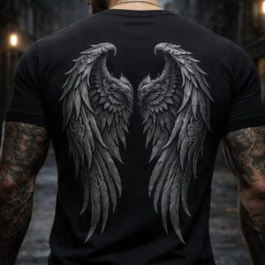 Puede incluir: Camiseta negra con un gráfico detallado en escala de grises de alas de ángel en la espalda. Las alas están intrincadamente diseñadas con detalles de plumas. La camiseta es de cuello redondo clásico.