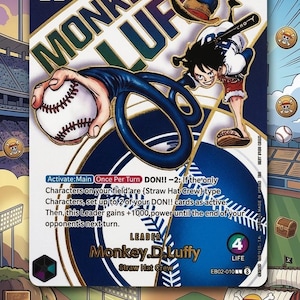 May include: A trading card featuring Monkey D. Luffy from One Piece, set against a baseball stadium backdrop. The card has a blue and gold color scheme, with Luffy holding a baseball bat and a baseball. The text includes "Monkey D. Luffy" and game instructions.