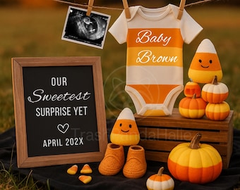 May include: A baby announcement scene with a white and orange striped babygrow, a sonogram, and a chalkboard sign. The display includes decorative pumpkins, candy corn, and baby booties, all set against a fall backdrop.