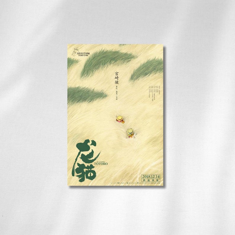 May include: A poster featuring the animated film "My Neighbor Totoro." The design includes Japanese text and illustrations of characters in a grassy field. The poster has a soft, warm color palette with green and yellow tones.
