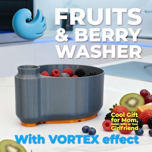Op de afbeelding: Een grijze fruit- en bessenwasser met een oranje basis, gevuld met frambozen, blauwe bessen en bramen. De tekst luidt "FRUITS & BERRY WASHER" en "With VORTEX effect". Een blauw vogelvormig logo staat in de linkerbovenhoek.