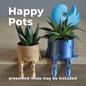 May include: Two small, smiling plant pots with succulents. One is tan, the other is blue. Both have articulated legs. The text "Happy Pots" is above the pots, and "preserved moss may be included" is below.