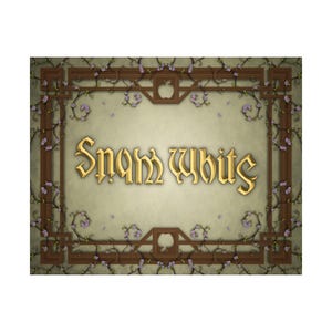 May include: A decorative rectangular sign with the words "Snow White" in gold lettering. The sign has a light green background with a brown border featuring apple and spade shapes, and purple floral accents.