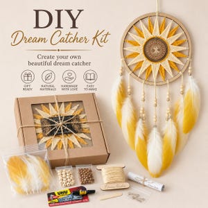 Op de afbeelding: Een DIY dromenvanger-set met een zonvormige geweven ring van geel en crèmekleurig garen, een centraal houten boomembleem en hangende veren. De set bevat een kartonnen doos, losse gele en witte veren, houten kralen, touw, lijm en metalen onderdelen.