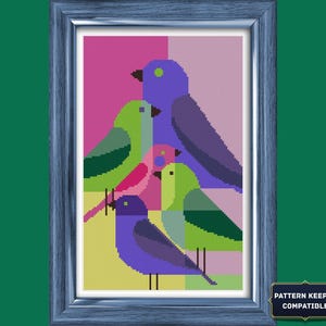 Pode incluir: Um padrão de ponto cruz com cinco pássaros estilizados em tons de roxo, verde e rosa, dispostos numa composição geométrica. O design está emoldurado em madeira azul e inclui uma etiqueta com o texto Pattern Keeper Compatible.