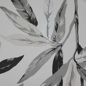 May include: A close-up of a wallpaper design featuring stylized leaves in shades of gray and black against a white background. The leaves have a feather-like appearance, with intricate veining details.