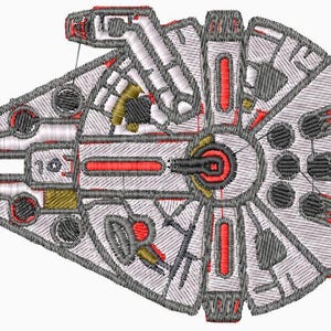 May include: Embroidered image of the Millennium Falcon starship, featuring a detailed design in white, gray, red, and gold thread. The ship's iconic shape is clearly defined, with intricate paneling and circular elements. The number "107" is visible.
