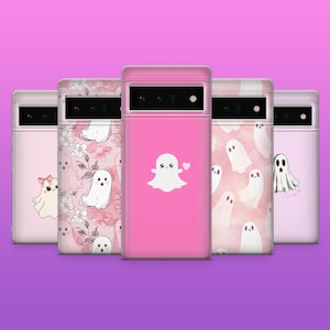 Può includere: Una collezione di cinque custodie rosa per telefoni con disegni di fantasmi. Le custodie presentano vari motivi, tra cui floreali, illustrazioni di fantasmi e un fantasma con un cuore. Le custodie sono esposte su uno sfondo viola.