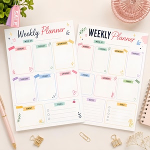 Peut inclure: Deux feuilles de planning hebdomadaire en papier blanc avec le texte Weekly Planner en écriture manuscrite bleu foncé et rose. Chaque feuille comprend des cases rectangulaires colorées pour les jours, une section objectifs et des motifs.