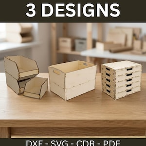 May include: Three light-coloured wooden storage organisers with the text 3 DESIGNS and DXF - SVG - CDR - PDF. The set includes a two-tier open bin, a rectangular crate with side handles, and a five-drawer unit, all featuring laser-cut edges.