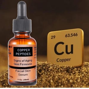 Peut inclure: Un flacon compte-gouttes en verre ambr&eacute; de s&eacute;rum pour le visage &eacute;tiquet&eacute; Copper Peptides pour les signes de l'&acirc;ge et la fermet&eacute; de la peau, contenant 30 ml (1 oz.). &Agrave; c&ocirc;t&eacute; se trouve un carreau carr&eacute; dor&eacute; affichant le symbole chimique Cu.