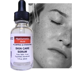 May include: A clear glass bottle of Alka Vita Hyaluronic Acid skin care serum with a black dropper cap. The label reads Hyaluronic Acid, Plumping & Hydrating, Skin Care Serum, Pure 100% From Eggshells Membrane, and 1 Fl oz. (30ml).