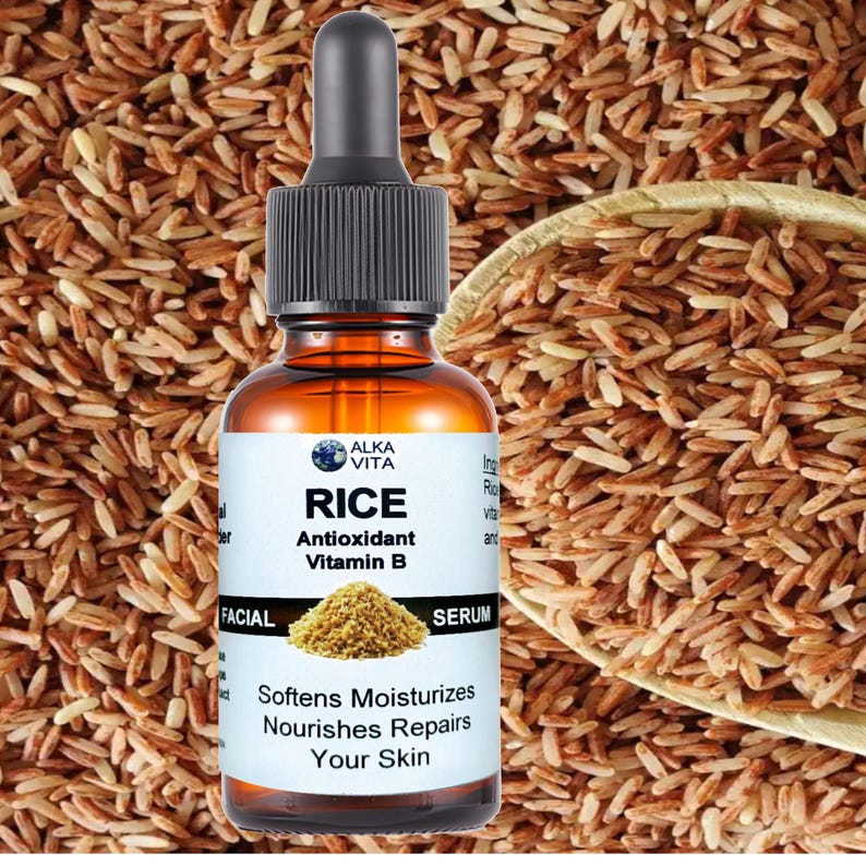 May include: An amber glass bottle with a black dropper cap containing facial serum. The white label features the text ALKA VITA, RICE, Antioxidant, Vitamin B, FACIAL SERUM, and Softens Moisturizes Nourishes Repairs Your Skin with a rice graphic.