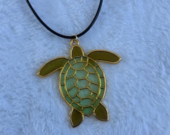 Collar de tortuga de resina con contorno dorado, joyería inspirada en la playa.