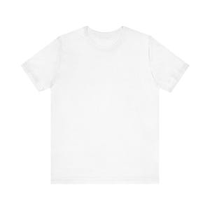 Puede incluir: Una camiseta blanca lisa con mangas cortas y cuello redondo. La camiseta está hecha de un material suave y opaco y es adecuada para ropa casual. Un básico de armario.