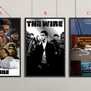 以下が含まれることがあります： 「The Wire」をテーマにした3枚の額入りポスター。ポスターAは登場人物のペイントコラージュとタイトル。ポスターBは白黒のグラフィックとタイトル。ポスターCは複数のパネルで構成されたシーンとタイトル、および「It's all in the game」というテキストが表示されています。