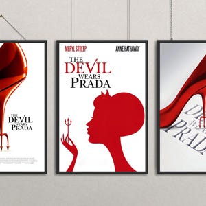 Könnte beinhalten: Set aus drei gerahmten Kunstdrucken mit dem Film "Der Teufel trägt Prada". Jeder Druck zeigt einen roten High Heel und den Filmtitel. Ein Druck enthält die Namen Meryl Streep und Anne Hathaway.
