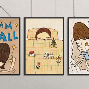 Puede incluir: Juego de tres impresiones artísticas enmarcadas con ilustraciones de dibujos animados. Una impresión dice "DAMN IT ALL" con una figura señalando. Otra muestra a una persona en la cama, y la tercera dice "Don't Wanna Cry."