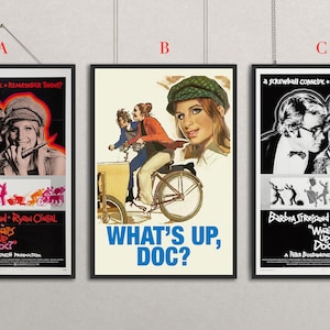 Puede incluir: Se muestran tres carteles de la película "¿Qué pasa, doctor?". Los carteles presentan a Barbra Streisand y Ryan O'Neal. Los carteles tienen un fondo negro con el título de la película y los créditos. El cartel B tiene un fondo crema.