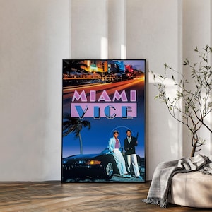 Op de afbeelding: Een rechthoekige wandkunstprint met het Miami Vice-logo in roze en paarse tekst over een donkerblauwe nachtscène. De afbeelding toont twee figuren die naast een zwarte sportwagen staan met palmbomen en stadslichten op de achtergrond.