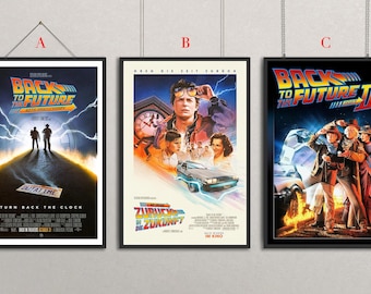May include: Three framed movie posters from the "Back to the Future" film series. The posters feature vibrant colours, including blues, oranges, and yellows, with iconic imagery from the films. Each poster is in a black frame and is hanging from a silver chain.