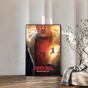 May include: A framed poster featuring a close-up of a person wearing a red and black spider-themed suit under a light-colored hoodie. The text Spider-Man Brand New Day is printed in red and blue at the bottom, with a small figure leaping in the air.