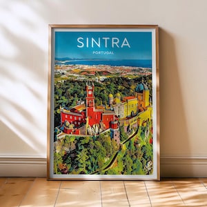 May include: A framed print of Sintra, Portugal, with the word "Sintra" in white text. The print depicts a vibrant palace on a green hillside, set against a blue sky and sea. The frame is gold-coloured.